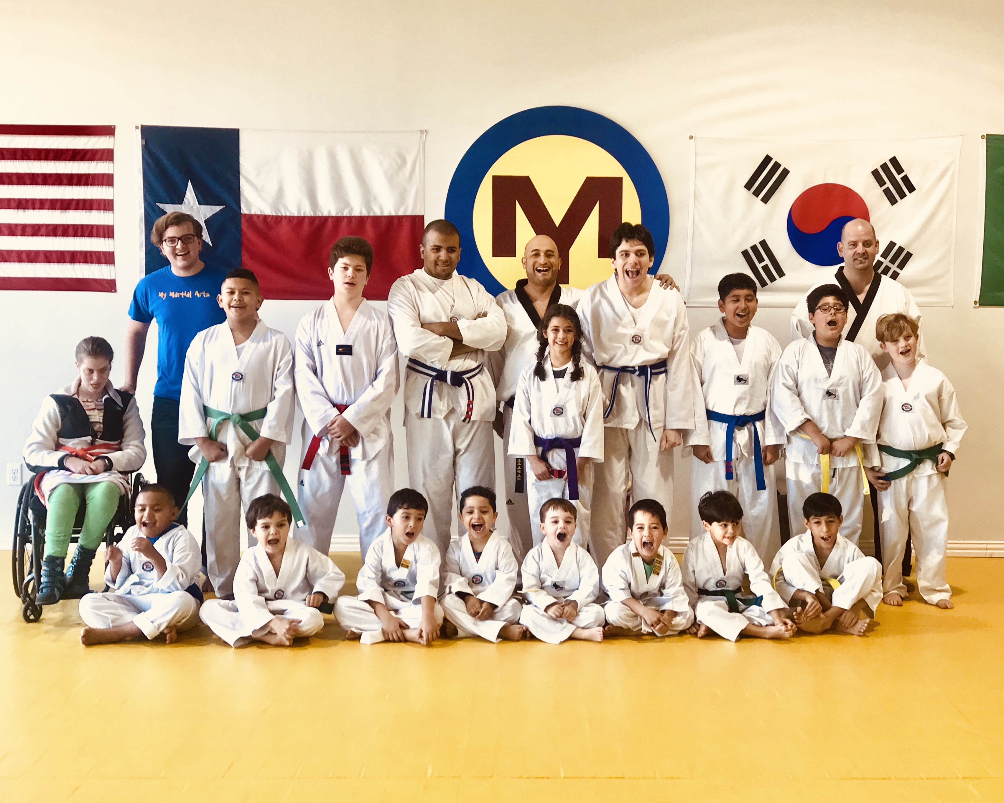 The My Martial Arts class on the yellow mat, students and instructors together, including a student using a wheelchair